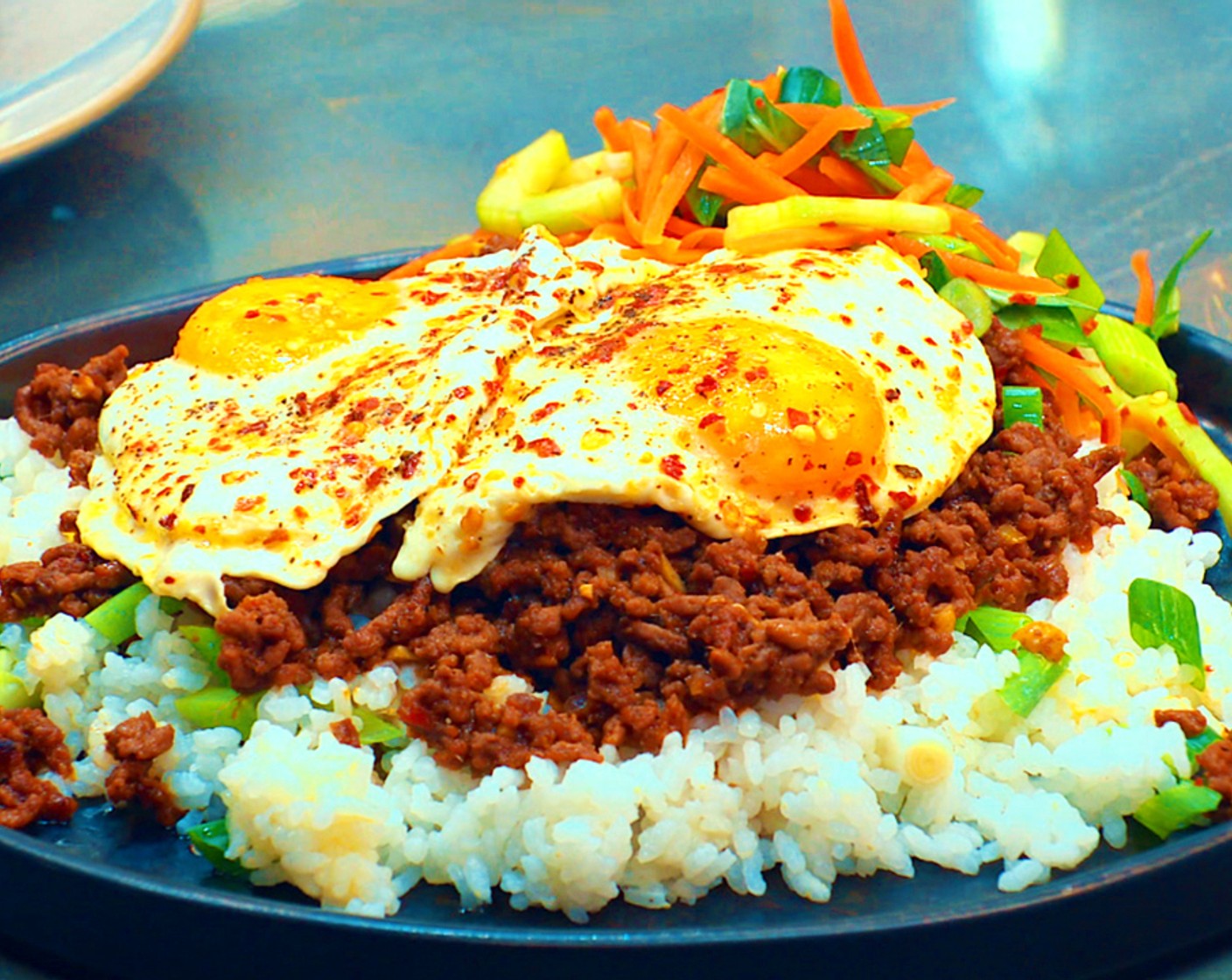 step 12 Top with the crispy beef and fried eggs and serve with a side of the pickled veggies.