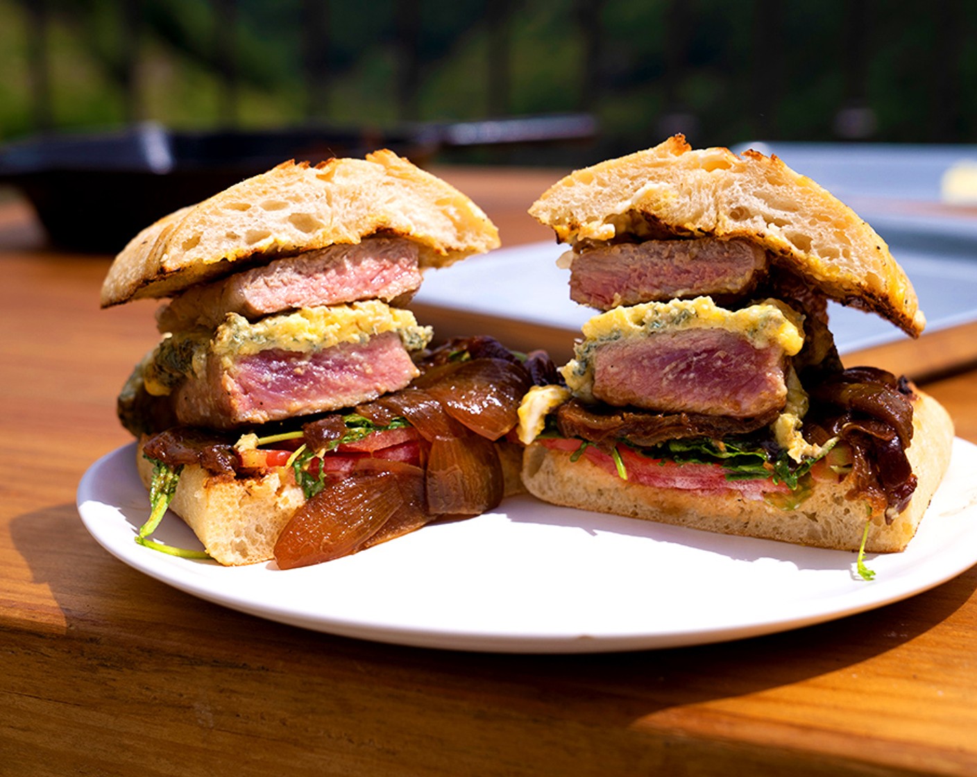 step 9 Add the steak and melted blue cheese to the sandwich and place the top piece of bread on top. Slice sandwich in half.