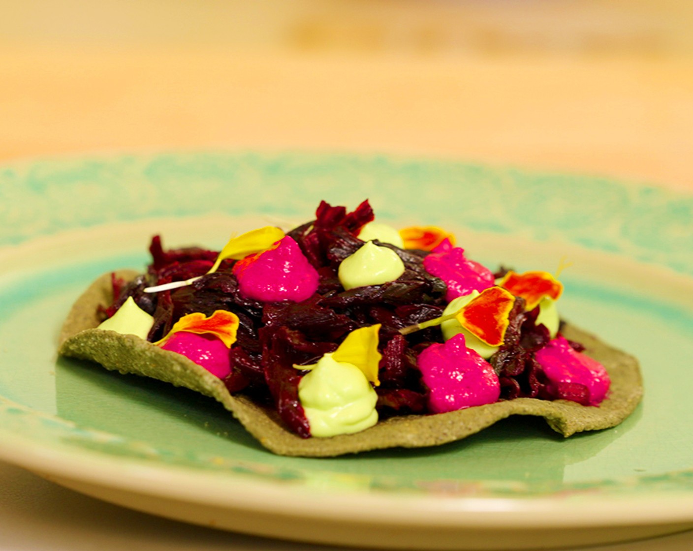 step 6 Assemble: Divide the hibiscus between the Tostada Shells (10) and top with beet yogurt, avocado mousse, and Salsa Verde (to taste). Garnish with Marigold Petals (to taste).