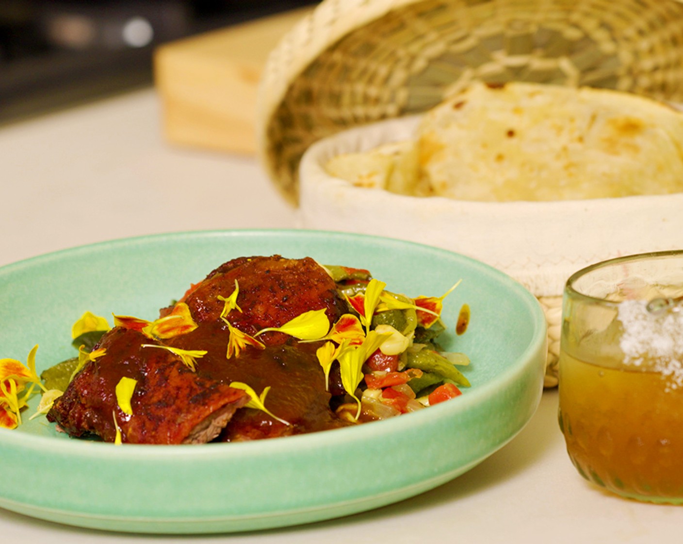 step 9 Plating: Serve the goat with warm Flour Tortillas (as needed) and drizzle with the prune sauce and Marigold Petals (to taste).