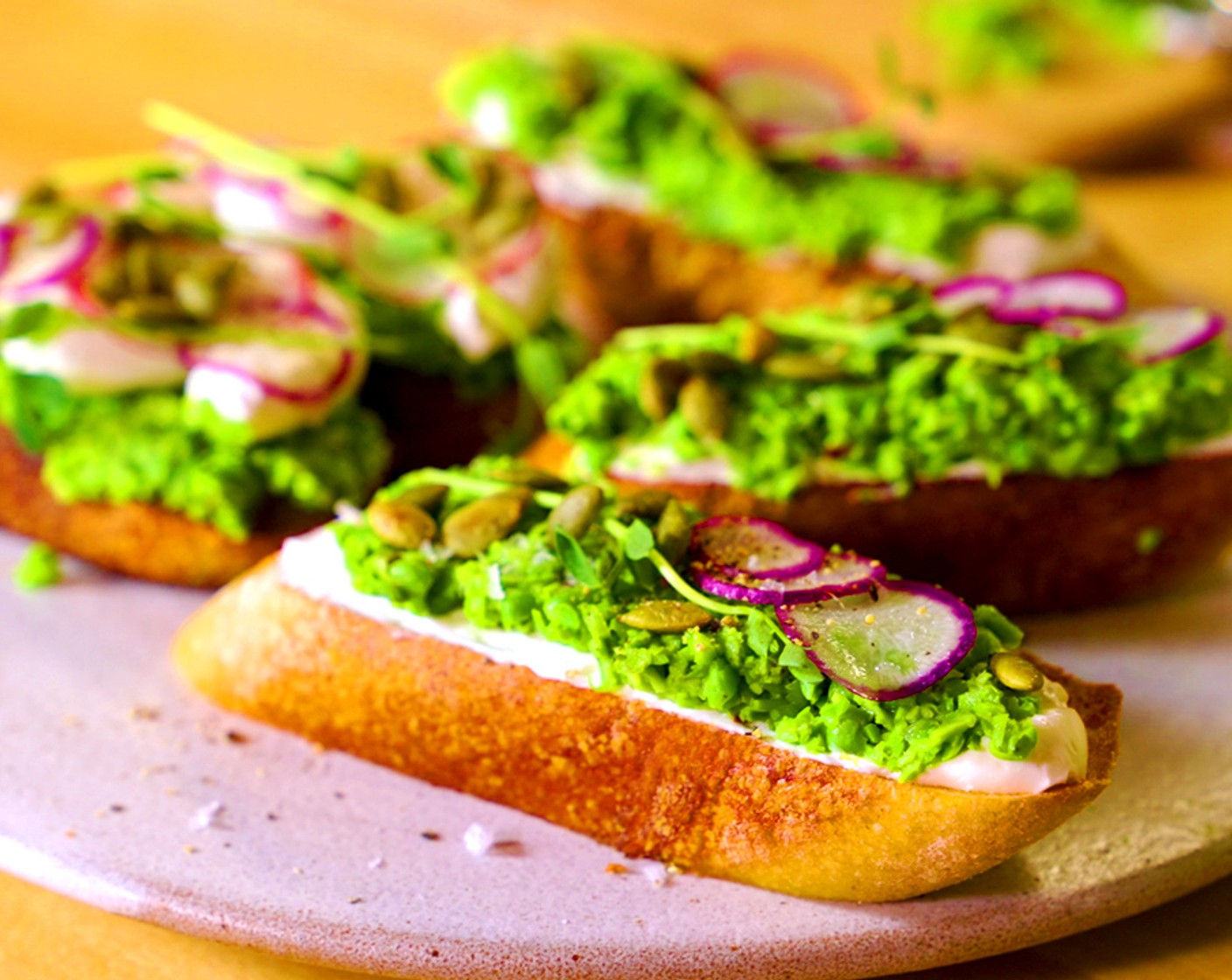 step 11 Assembly: Place a dollop of pea puree onto each piece of toast followed by the whipped ricotta, Watermelon Radishes (to taste),Pea Shoots (to taste) or tendrils, and Roasted Pepitas (to taste) Season with Coarse Sea Salt and Pepper (to taste).