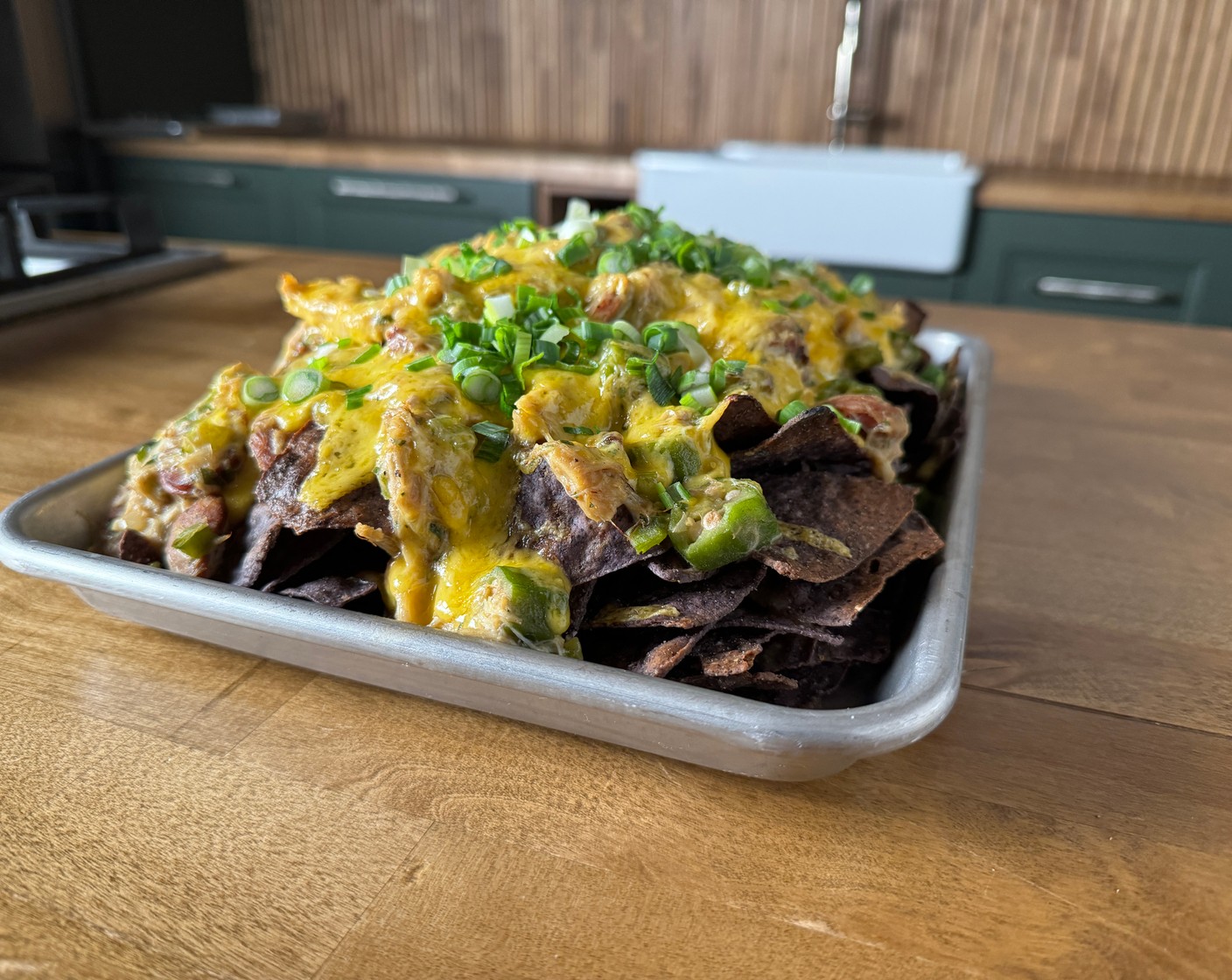 step 6 To assemble: Add the Tortilla Chips (to taste) to a large serving platter or half sheet tray. Season the chips with more creole seasoning, if desired. Top the chips with the gumbo and Shredded Mild Cheddar Cheese (2 cups). If you’d like you can place the nachos in a hot oven to melt the cheese. Garnish with Scallions (4 Tbsp) and serve immediately!