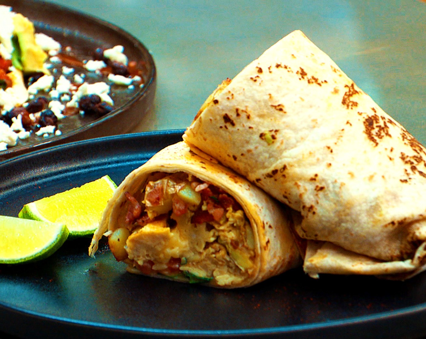 step 5 Assemble: Warm the Large Flour Tortillas (2) and divide between two plates. Layer the tortillas with bacon, potatoes, eggs, Shredded Cheddar Cheese (1 cup), pico de Gallo, and Avocado (1).