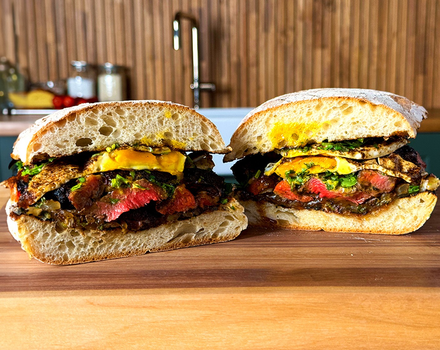 step 6 Assemble: Slice the steak and squeeze fresh Lime (1) juice and sprinkle Sea Salt Flakes (to taste) across the steak. Place the bottom of the toasted ciabatta on a flat surface and top with the steak, fried eggs and Fresh Cilantro (1 bunch).