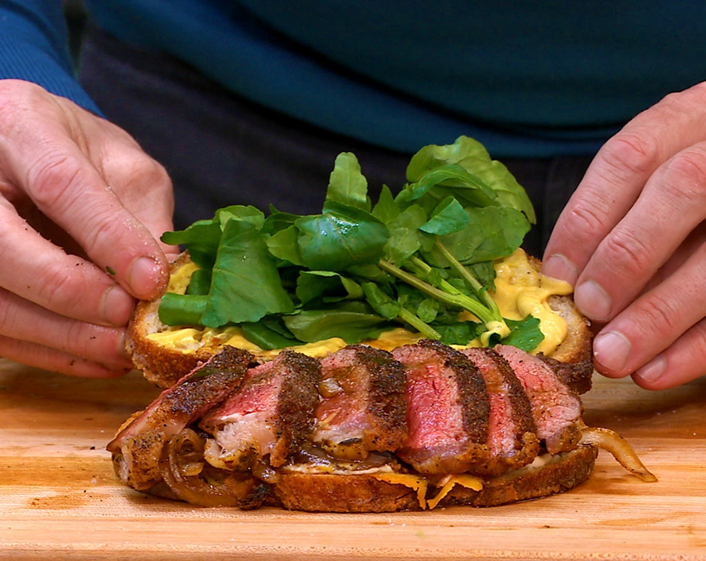 step 10 Slice the steak and season again with salt. Shingle the steak on the onions and top with the other slice of bread. Serve with additional watercress on the side.