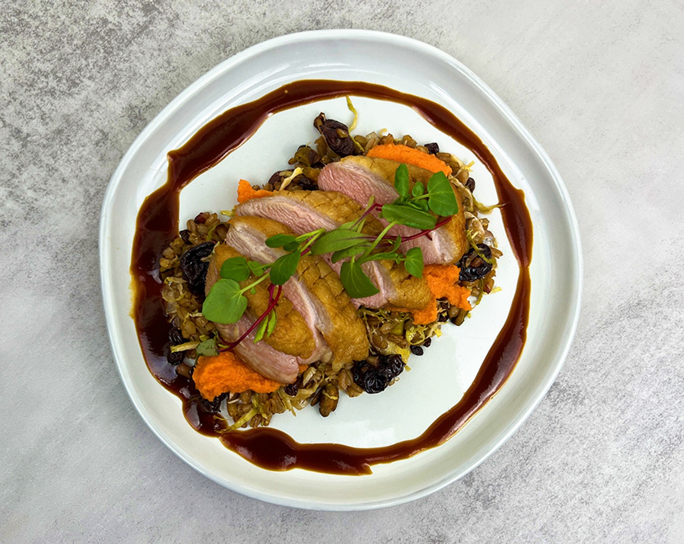 step 4 Place the farro mixture onto the plate and top with the sliced duck. Add a scoop of the Sweet Potatoes (2 oz) and drizzle the cherry jus around the duck. Finish with the Watercress (to taste).