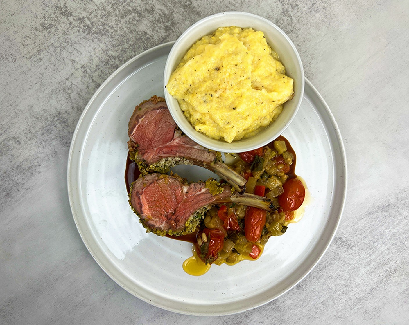 step 5 For serving: Slice the lamb between the bones and plate on top of the caponata and finish with the Au Jus (to taste) Serve with the Polenta (to taste)