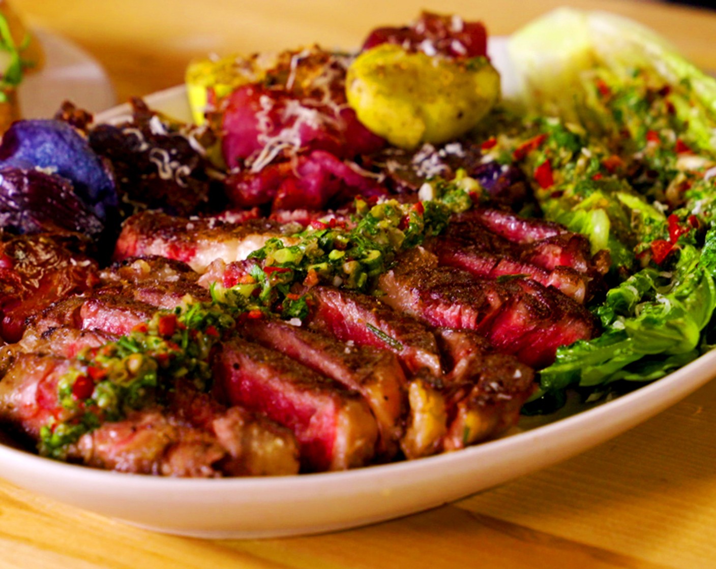 step 14 Assemble: On a cutting board, slice steak into ½-inch slices, then transfer to plates. Add potatoes, grilled romaine drizzle everything with salsa verde. Sprinkle Grated Parmesan Cheese (1/2 cup) over the top.